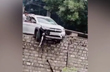 Car dangles from 25-foot wall after 