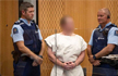 Barefoot, handcuffed, New Zealand shooter smirks in court